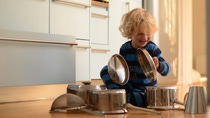 blond child playing drums with pots and pans blond child playing drums with pots and pans