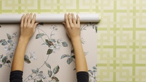 Woman wallpapering wall, close-up Woman wallpapering wall, close-up