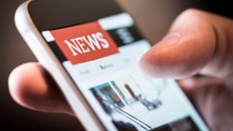 Online news in mobile phone. Close up of smartphone screen. Man reading articles in application. Hand holding smart device. Mockup website. Newspaper and portal on internet. Online news in mobile phone. Close up of smartphone screen. Man reading articles in application. Hand holding smart device. Mockup website. Newspaper and portal on internet.