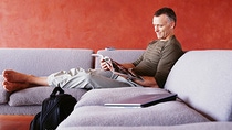 Mature man reading magazine on sofa Mature man reading magazine on sofa