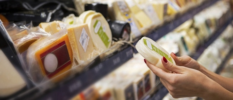 Woman buying cheese ina supermarket