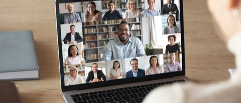 Back view of female employee speak talk on video call with diverse multiracial colleagues on online briefing, woman worker have Webcam group conference with coworkers on modern laptop at home