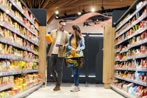 A couple in a store with food packagings and sustainable products A couple in a store with food packagings and sustainable products